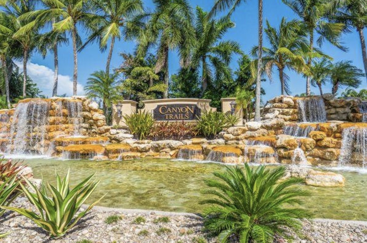 Canyon Trails waterfall entrance and palm-lined community in Boynton Beach, Florida
